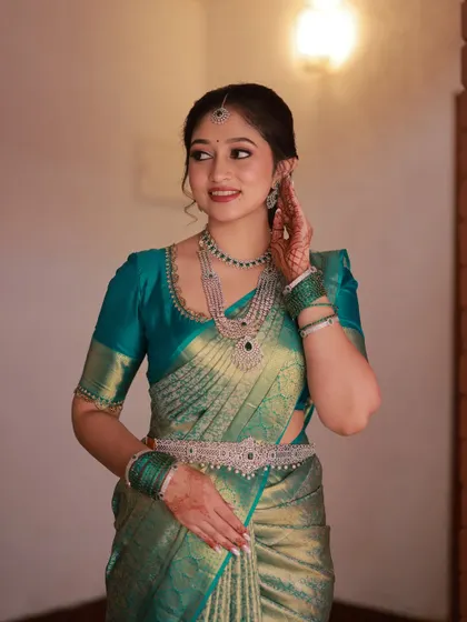 A candid moment of the bride adjusting her jewellery. Her makeup looks fresh and flawless, even in an unposed shot.