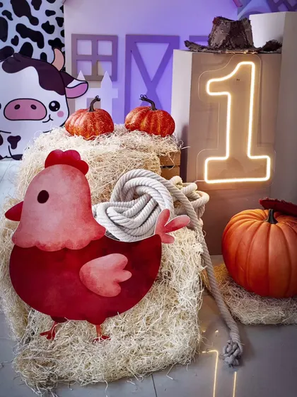 A close-up of the no-balloon farm theme, showing the adorable chicken cutout, hay, and pumpkin props.