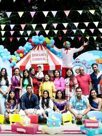 A group photo of all the guests in front of the main carnival stage, capturing a happy memory of the celebration.