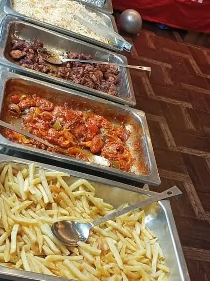 A close-up of some kid-friendly party food, including french fries and pasta, perfect for a birthday celebration.