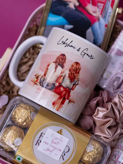 A personalized friendship mug with a custom illustration and the names 'Lakshmi & Gouri'. This is a perfect centerpiece for a best friend's birthday hamper.