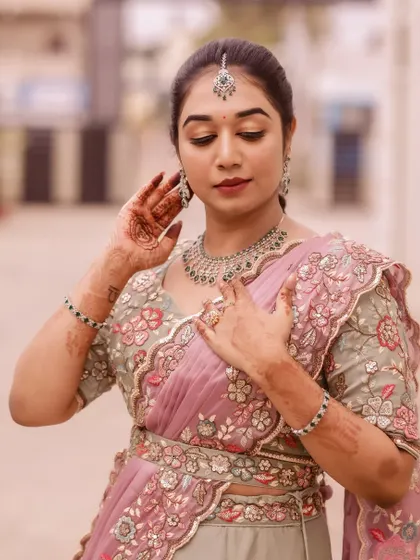 This bride looks elegant in a pastel pink and grey lehenga. The makeup is soft and romantic, with a focus on glowing skin and beautifully defined eyes.