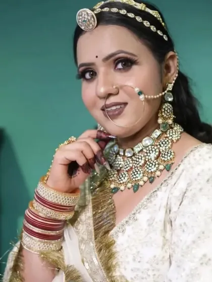 A bride showcasing a traditional Rajasthani look with a heavy Kundan and emerald choker, a borla mathapatti, and a large nath. This set is perfect for achieving an authentic Rajputi bride style.
