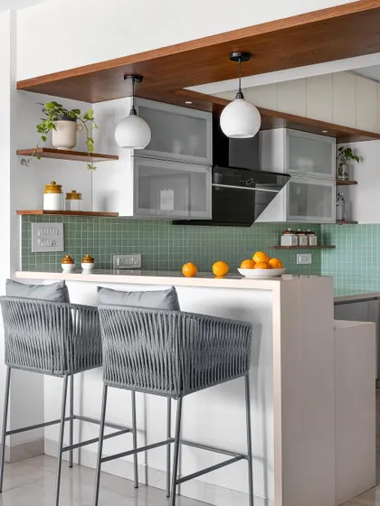 The open-plan 'Gulmohar' kitchen features a breakfast counter that encourages casual conversations and makes the space feel connected to the dining area.
