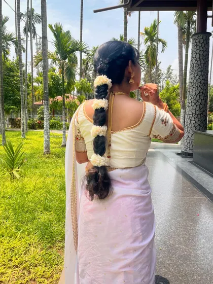 A look at the back of the simple yet elegant white blouse and traditional hairstyle.