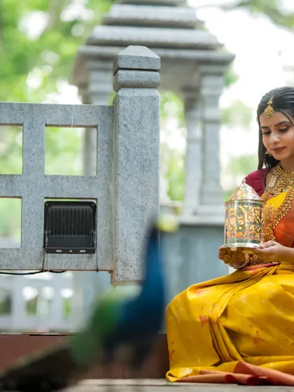 The peacock looking on as the model holds the lantern, a beautiful and symbolic image.