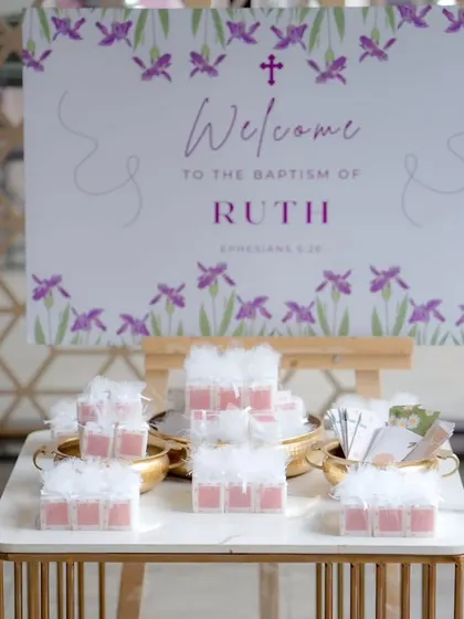 Another view of the Baptism welcome table, showing the custom-designed sign and beautifully arranged party favors for guests.