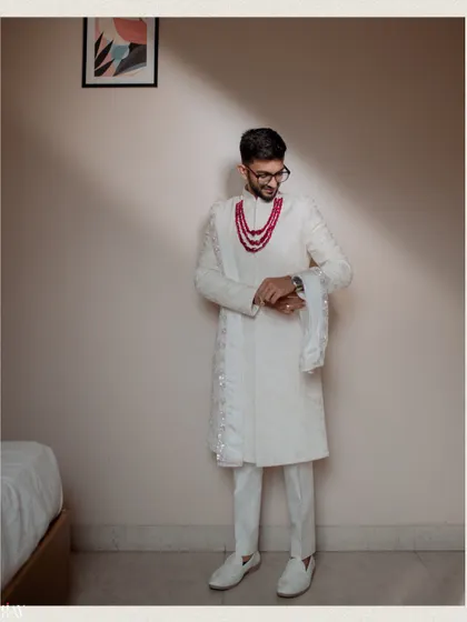 The groom checks his watch, a classic pose captured with dramatic lighting.