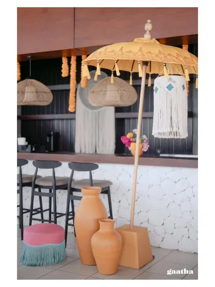 The bar area decorated with terracotta vases, a yellow Balinese umbrella, and macrame details, ensuring every corner of the venue is picture-perfect.