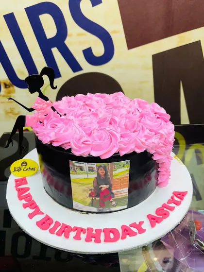 A chic 1.5kg cake with a silhouette of a girl, a cascade of pink rosettes, and a personal photo.