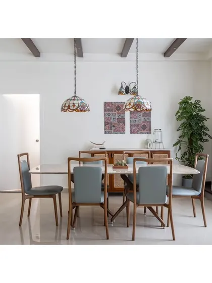A full view of the eight-seater dining table, perfect for family gatherings. The combination of the stone top, leather chairs, and decorative lighting creates an elegant yet comfortable dining experience.