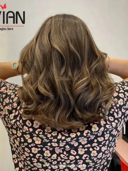 This client's medium-length hair is brought to life with soft, natural-looking highlights. The waves add texture and show off the subtle variations in tone.