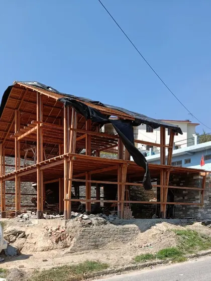 **Market Plaza, Champawat:** The full wooden frame of the two-story market building under construction. The design is light and open, intended to be a bustling hub for the local community.