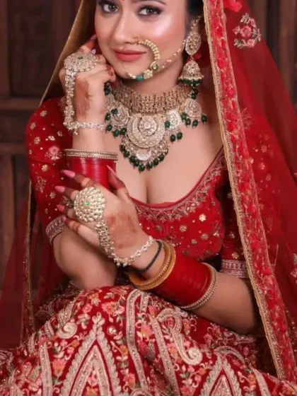 A close-up of a bride wearing a Kundan set with green bead details. You can see the matching nath, earrings, and haath phool that complete the look.