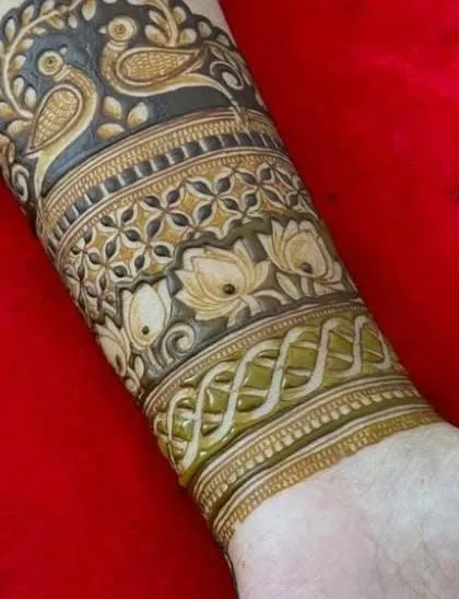 The completed armband, with the bird motif at the top and intricate bands of lotus and geometric patterns below.