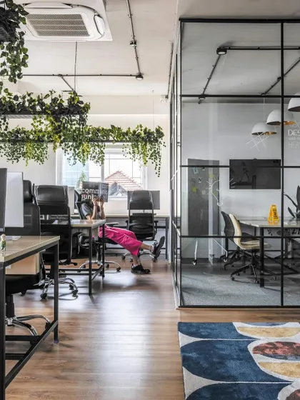 An open workstation area at LWYD, viewed through a glass-walled meeting room. This design choice promotes transparency and connection while still providing acoustic separation for focused discussions.