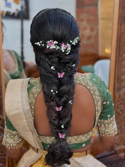 A whimsical and romantic braid adorned with delicate butterfly clips and baby's breath. This style is perfect for a mehendi or a fairytale-themed wedding.