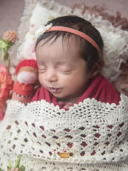 A closer look at this sweet setup, focusing on the baby's face and the texture of the blanket. The warm tones create a very comforting feel.
