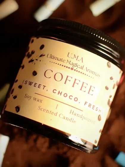A close-up of the 'Coffee' candle label. The fragrance notes are sweet, choco, and fresh, making it a truly comforting and warm hug in a candle.