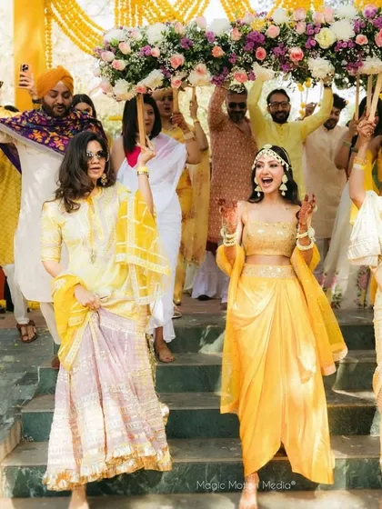 The bride's joyful entrance with her family, all celebrating under a beautiful floral canopy. The energy is infectious and the decor is full of life.