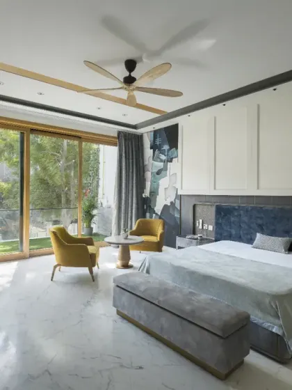 The ground-floor parents' bedroom in the Screen House uses a palette of white with accents of grey and blue. Thoughtfully placed furniture and clean lines enhance the sense of openness, while the connection to the balcony brings in the outdoors.