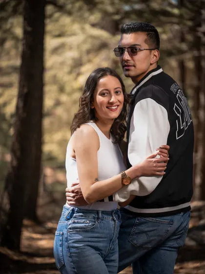 A classic couple portrait in the woods, embracing and smiling for the camera. A great shot for capturing a happy memory.