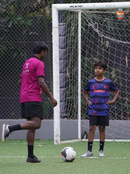 A coach demonstrating proper technique to a young player. Our 1-on-1 sessions are tailored to address specific areas of improvement.