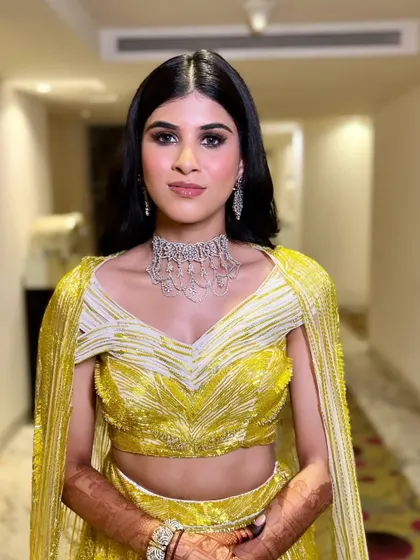 A beautiful shot of the bride in her yellow sangeet outfit. The makeup is kept bright and glowing to match the energy of the event.
