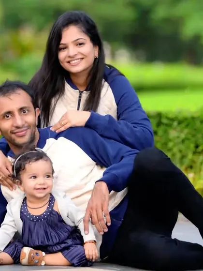 A relaxed outdoor family portrait in a park setting. We guide families into comfortable poses that feel natural and showcase their loving bond.
