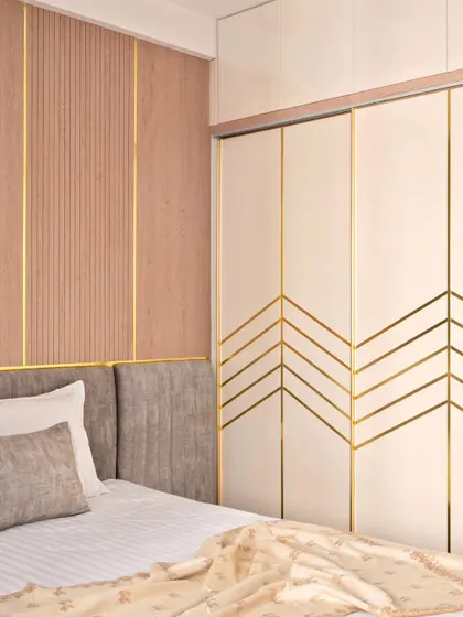 The parents' bedroom in 'Muditā' features a wardrobe with sliding doors that have a chevron pattern in gold T-patti, adding a touch of glamour.
