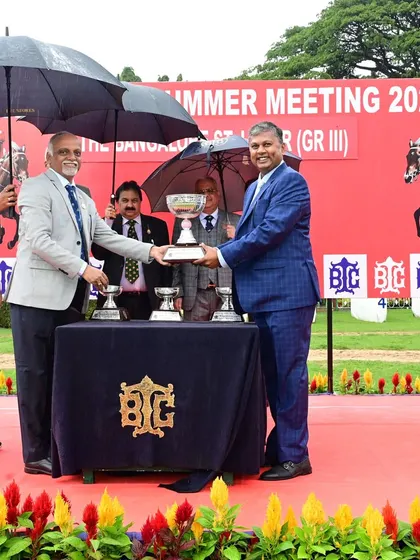 The Chairman, Mr. R. Manjunath Ramesh, presents The Bangalore St. Leger (GR III) trophy to the owner of Golden Thunder, even as the rain comes down.