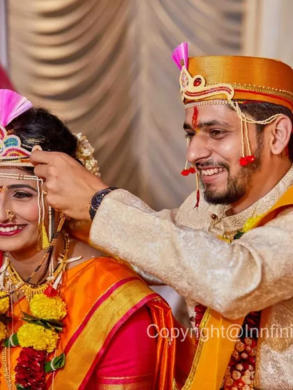 Another beautiful moment from a Maharashtrian wedding. The genuine smiles as they share this small interaction make the photo feel warm and authentic.