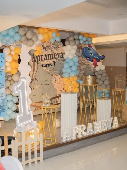 For the little explorer, I designed this travel-themed birthday party. The decor includes a world map backdrop, a large chalkboard with the baby's milestones, and props like a hot air balloon and an airplane.
