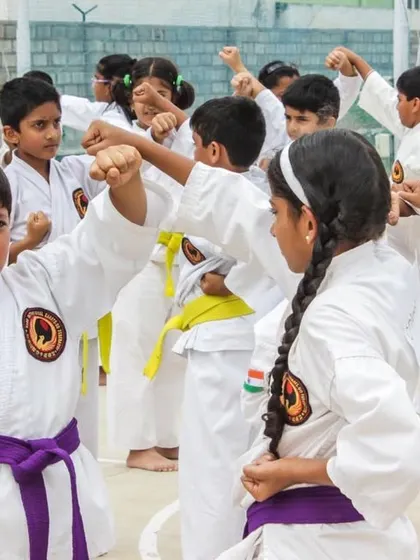 Young students practicing blocks and punches. This drill helps them develop muscle memory for essential self-defense movements.