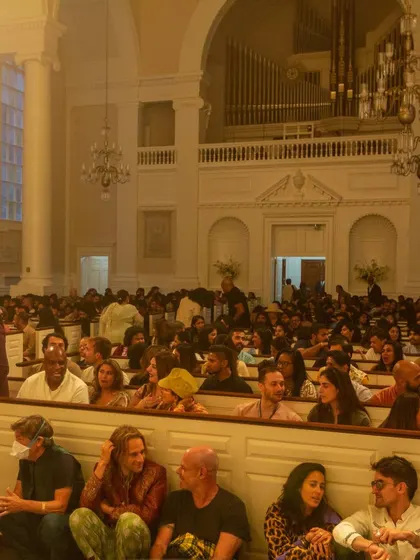 The audience fully engaged and seated on the floor, creating a sense of community and shared experience.
