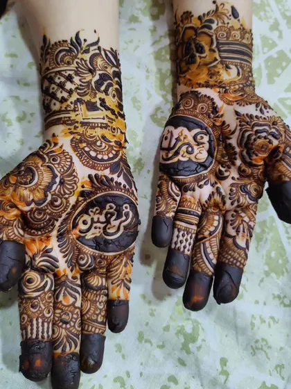 A heavy bridal design with two different names in Arabic script featured prominently on each palm.