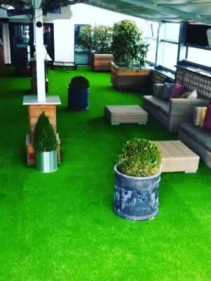 I can cover entire floors with artificial grass, as seen in this lounge area. This is a great option for rooftop bars, balconies, or indoor recreational areas to create an outdoor feel.