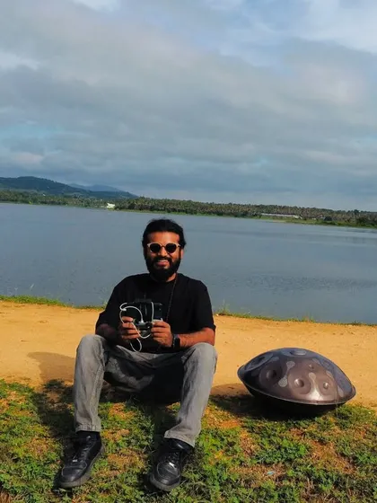 A photo of me with my handpan by a serene lake.