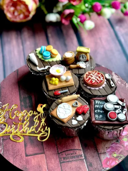 My custom cupcakes are tiny canvases for edible art. This set was designed for a fellow baker, featuring incredibly detailed, handmade fondant toppers that represent the tools of our trade, from a miniature pie and macarons to a tiny scale and rolling pin.