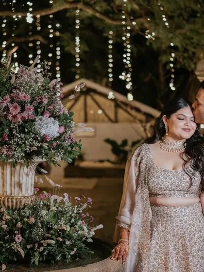 A portrait of the couple is a timeless memory. Ridhi and Prashanth stand on their candlelit stage, a moment of quiet elegance amidst their romantic cocktail party.