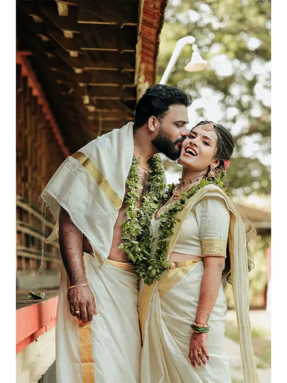 A joyful and affectionate kiss on the cheek, capturing a candid moment of love.