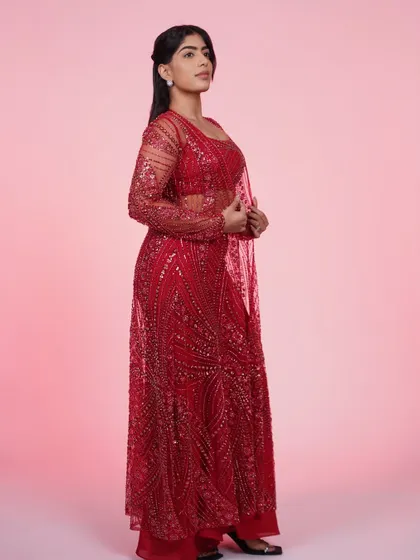 A side view of the red three-piece set, highlighting the sheer, sequined jacket and the flattering fit of the pants.