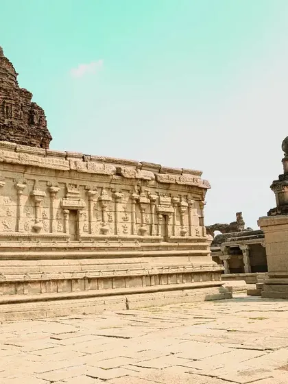A wider view of a temple complex in Hampi, showing the relationship between different structures and the surrounding space.