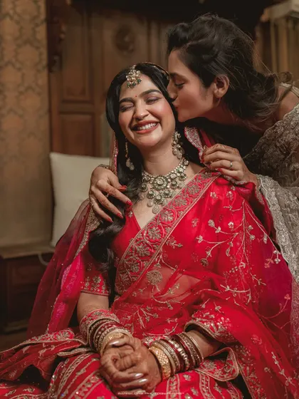 A sweet kiss on the cheek from a sister or friend. This photo is overflowing with love and happiness, a perfect candid moment.