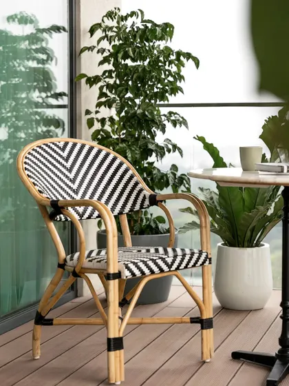 A close-up of the stylish rattan bistro chair, perfect for creating a Parisian cafe vibe on a home balcony.