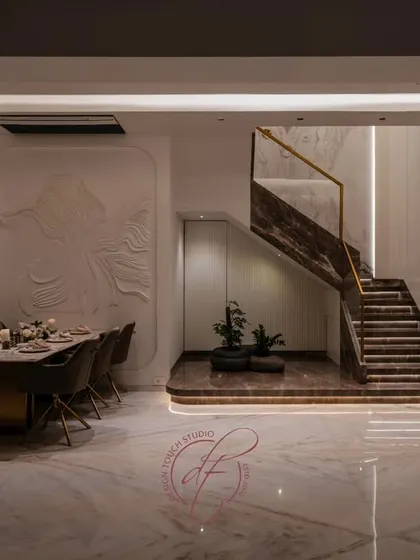 A grand staircase can be the soul of a home. For this duplex, we designed a 26-foot high book-matched marble wall, accented with ceramic and metal art. The automated, motion-sensing lights on the steps add a touch of modern magic, blending artistry with technology.