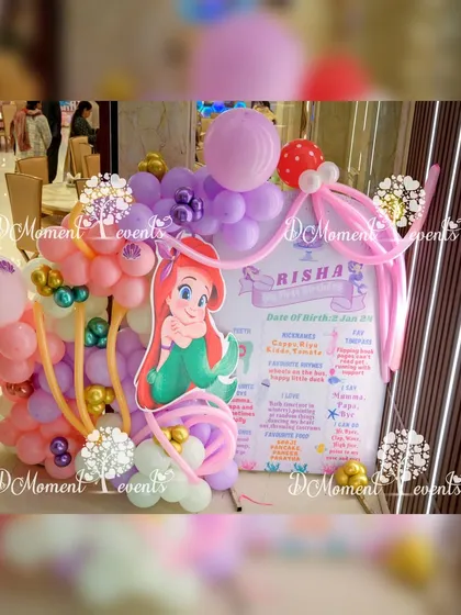 A milestone board for a mermaid-themed party, decorated with an elaborate, artistic balloon arrangement.