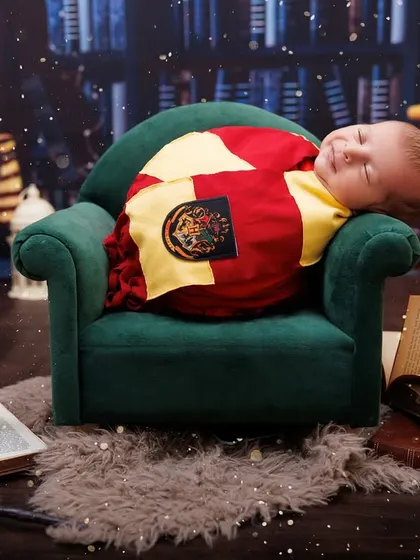 A magical smile from a sleeping baby in a full Harry Potter themed setup, complete with books and candles.