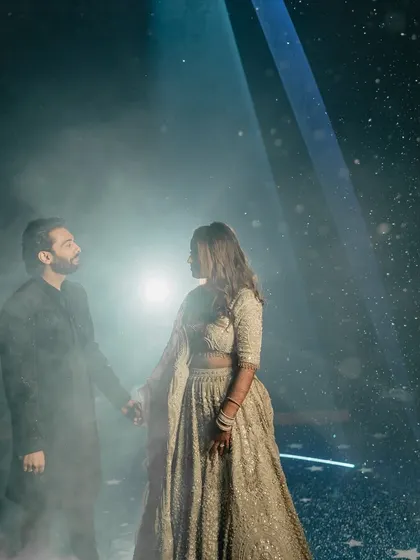 A stunning, moody portrait of the couple under a spotlight, creating a dramatic and cinematic feel for their Sangeet.