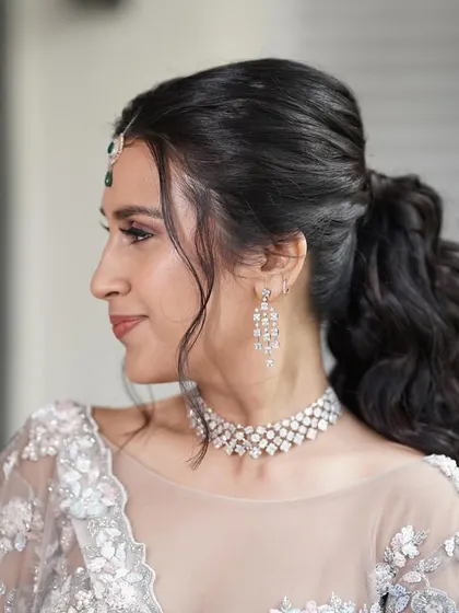 A close-up of the hair and makeup. The soft, textured ponytail and the clean makeup are a perfect combination for a modern bride.